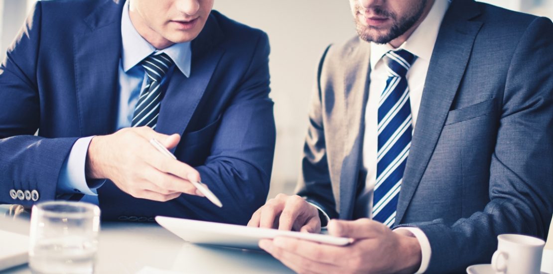 Image of two young businessmen discussing new project in office